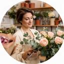 Florista principal colocando rosas y eucalipto en el taller de Camino de la Ribera