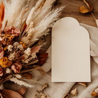 Ramo boho con pampas y flores secas colocado junto a una invitación de boda