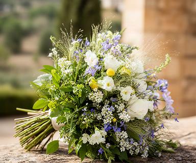 Ramo de novia silvestre con flores de campo recién cortadas y follaje verde en una finca andaluza